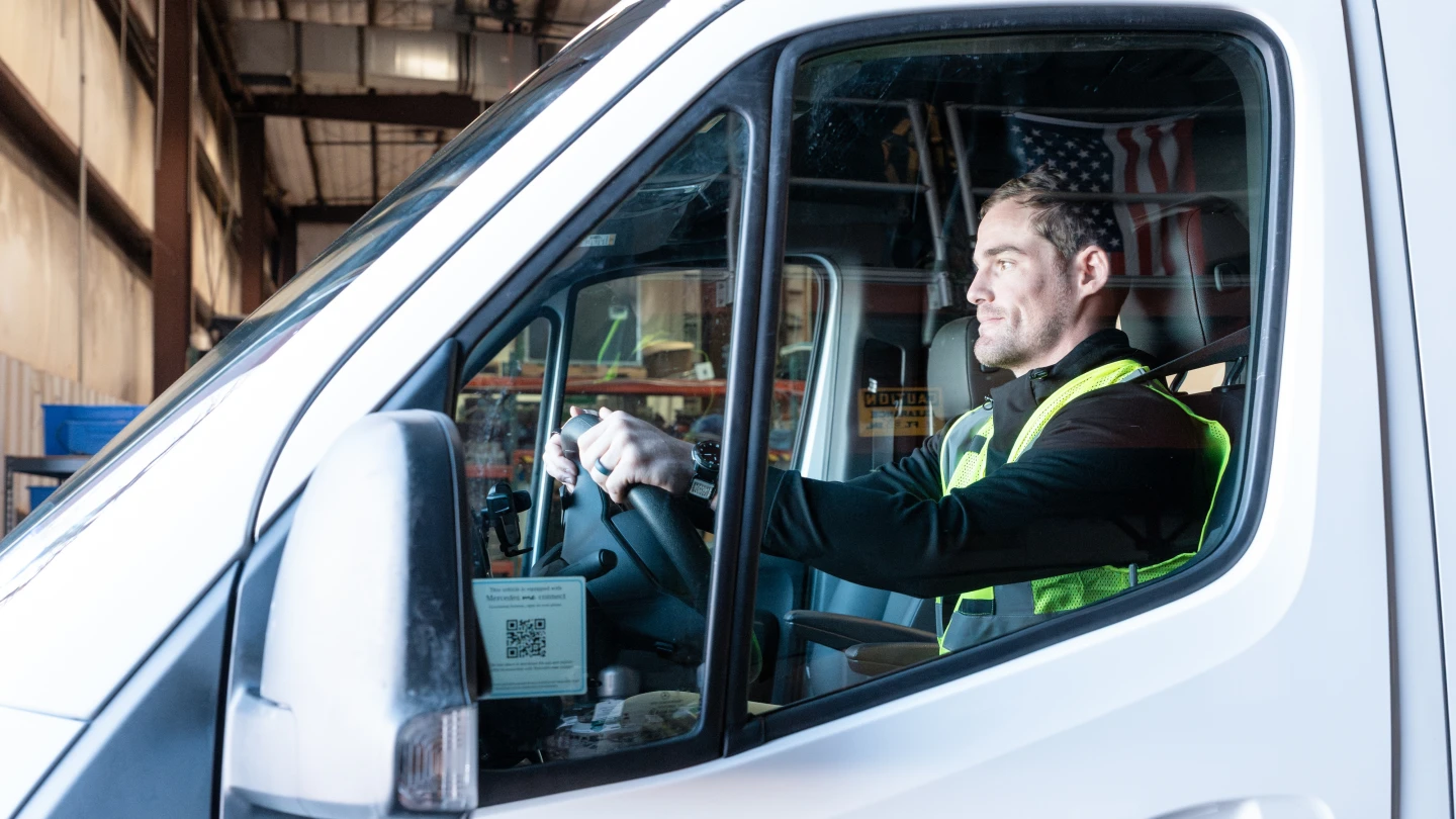 Field operations specialist driving a service vehicle to support environmental response and project delivery