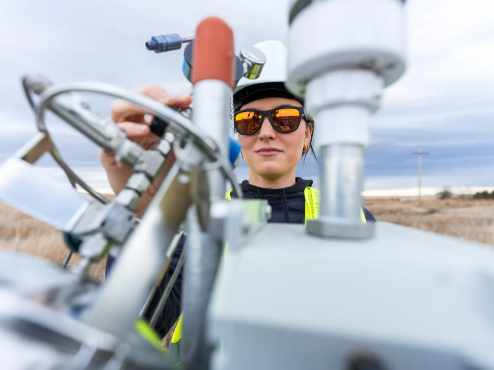Technician inspecting industrial equipment and control valves outdoors