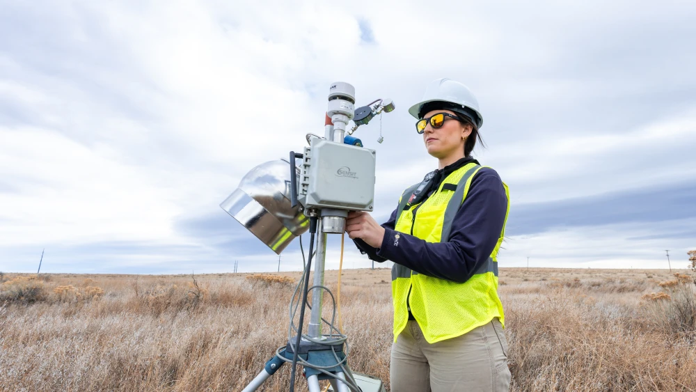 An Onterris employee setting up air sampling equipment in a field