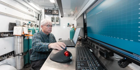 Environmental scientist analyzing monitoring data in a mobile laboratory