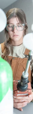 Employee calibrating equipment in a technical workspace.