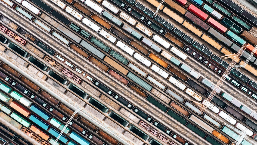 Aerial view of a rail yard with multiple freight trains and tracks arranged in parallel lines