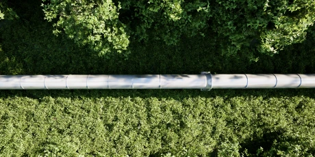 Aerial view of a pipeline running through a green forest landscape