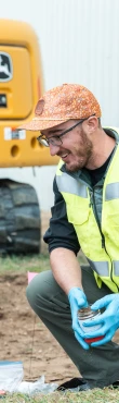 Environmental recovery specialist collecting field samples during post-incident remediation and site restoration activities.