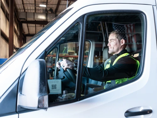 Field operations specialist driving a service vehicle to support environmental response and project delivery