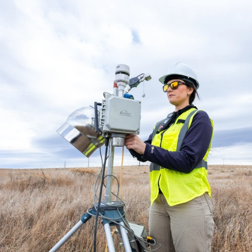 An Onterris employee setting up air sampling equipment in a field