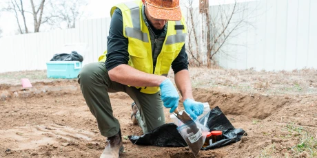 Environmental field technician collecting soil samples at an industrial site.