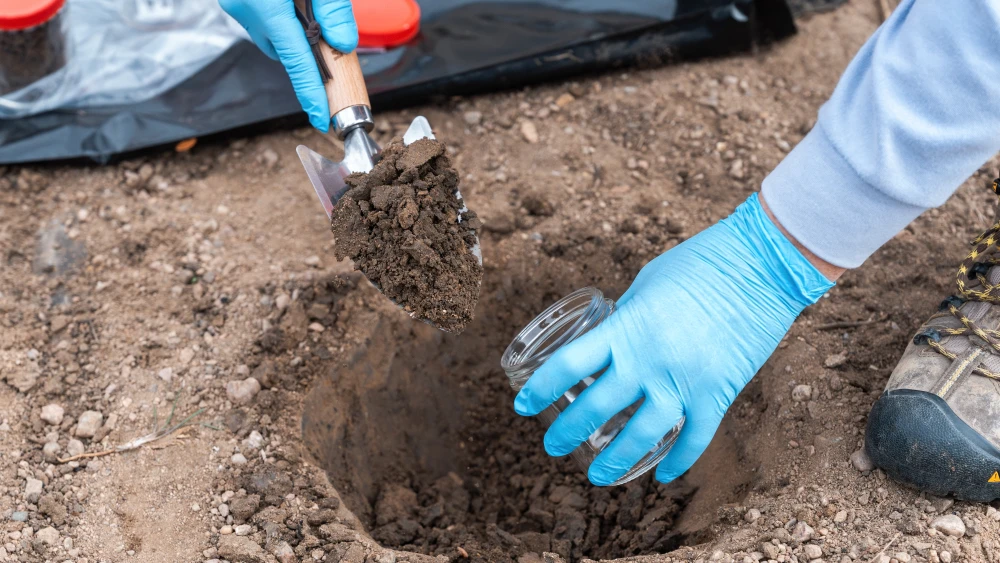 Environmental technician collecting soil samples for contamination analysis and remediation planning.
