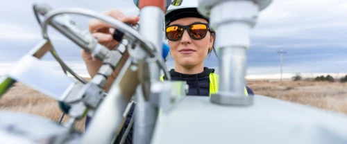 Technician inspecting industrial equipment and control valves outdoors