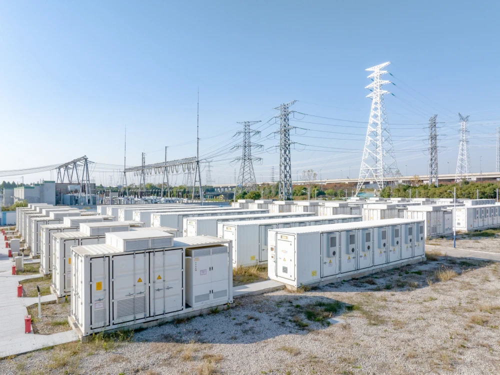 Battery storage units and power lines at an electrical substation.