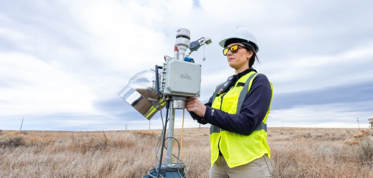 An Onterris employee setting up air sampling equipment in a field
