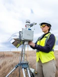 An Onterris employee setting up air sampling equipment in a field