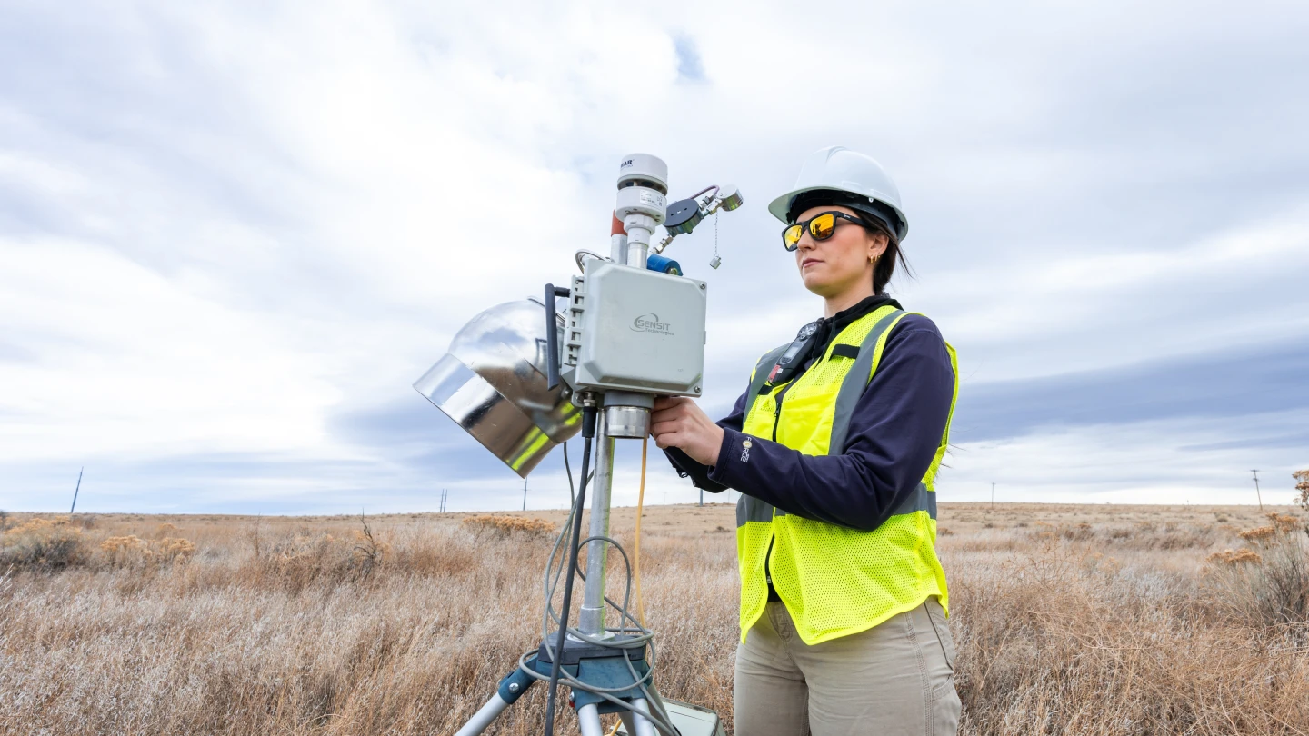 An Onterris employee setting up air sampling equipment in a field