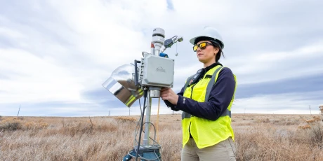 An Onterris employee setting up air sampling equipment in a field